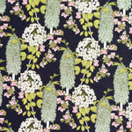 Detail of fabric in a dense floral print in pink, green and yellow on a navy field.