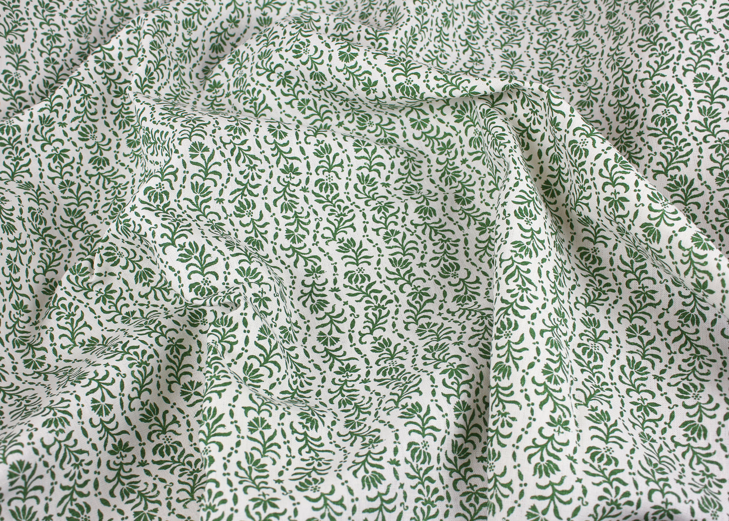 Draped printed linen in a wavy floral stripe design in green on white. 