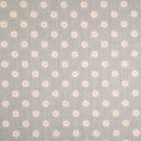 Detail of fabric in a playful dot print in pink and cream on a gray field.