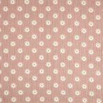 Detail of fabric in a playful dot print in gray and white on a mauve field.