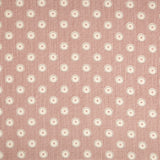 Detail of fabric in a playful dot print in gray and white on a mauve field.