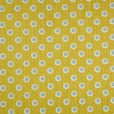 Detail of fabric in a playful dot print in blue and white on a mustard field.