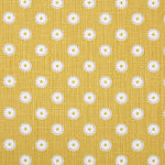 Detail of fabric in a playful dot print in white and gray on a mustard field.