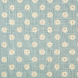 Detail of fabric in a playful dot print in white, gray and tan on a blue field.