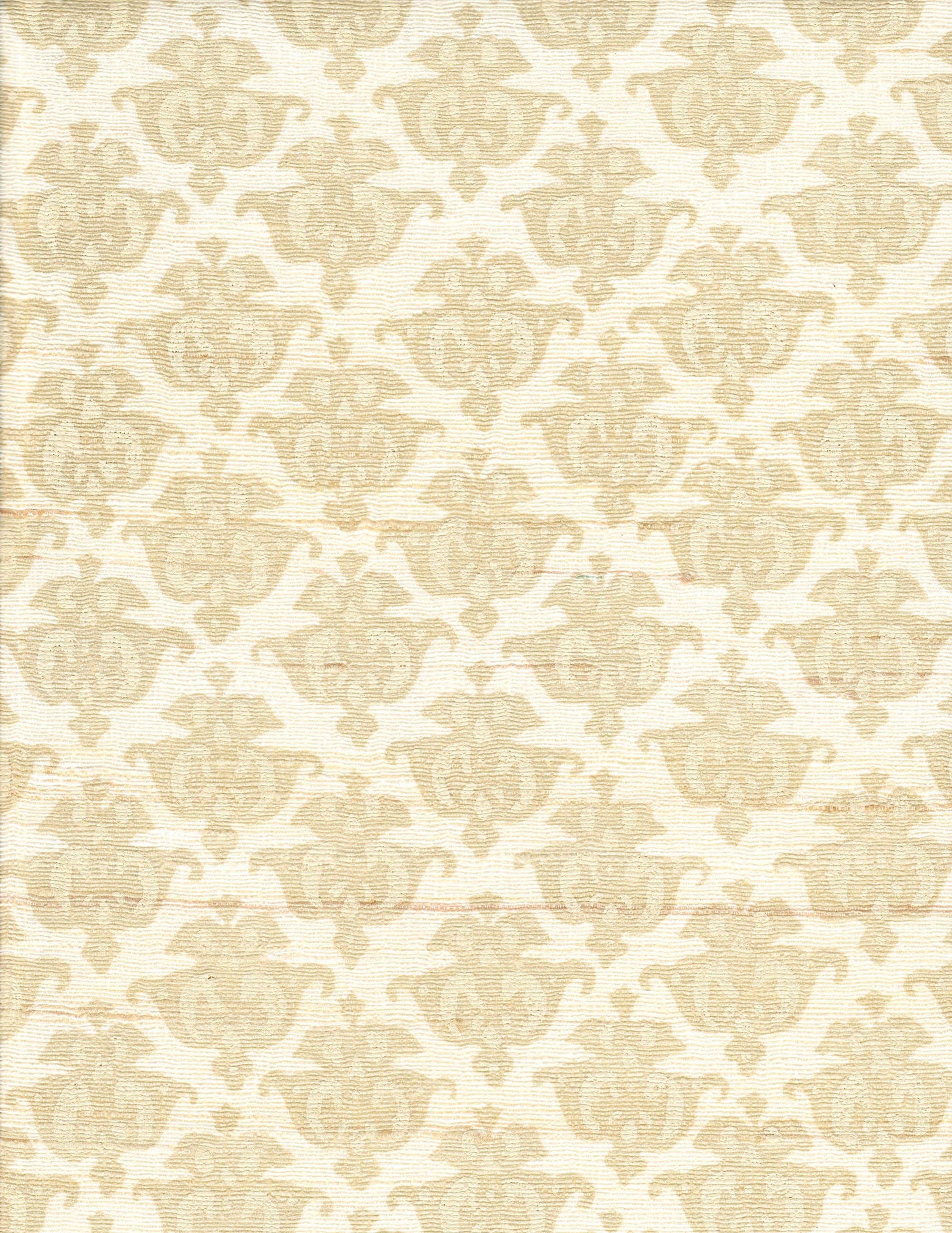 Detail of fabric in a repeating damask print in tan and cream on a white field.