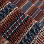 Detail of a complex woven striped runner made of wool in shades of blue and red. 