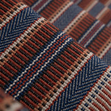Detail of a complex woven striped runner made of wool in shades of blue and red. 