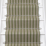 White stair case with a complex woven striped runner made of wool in shades of green with grey and red accents.
