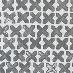 Close-up of wallpaper in a repeating "X" print in gray on a white field.