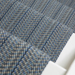 Close-up of a stair runner in blue-gray herringbone weave.