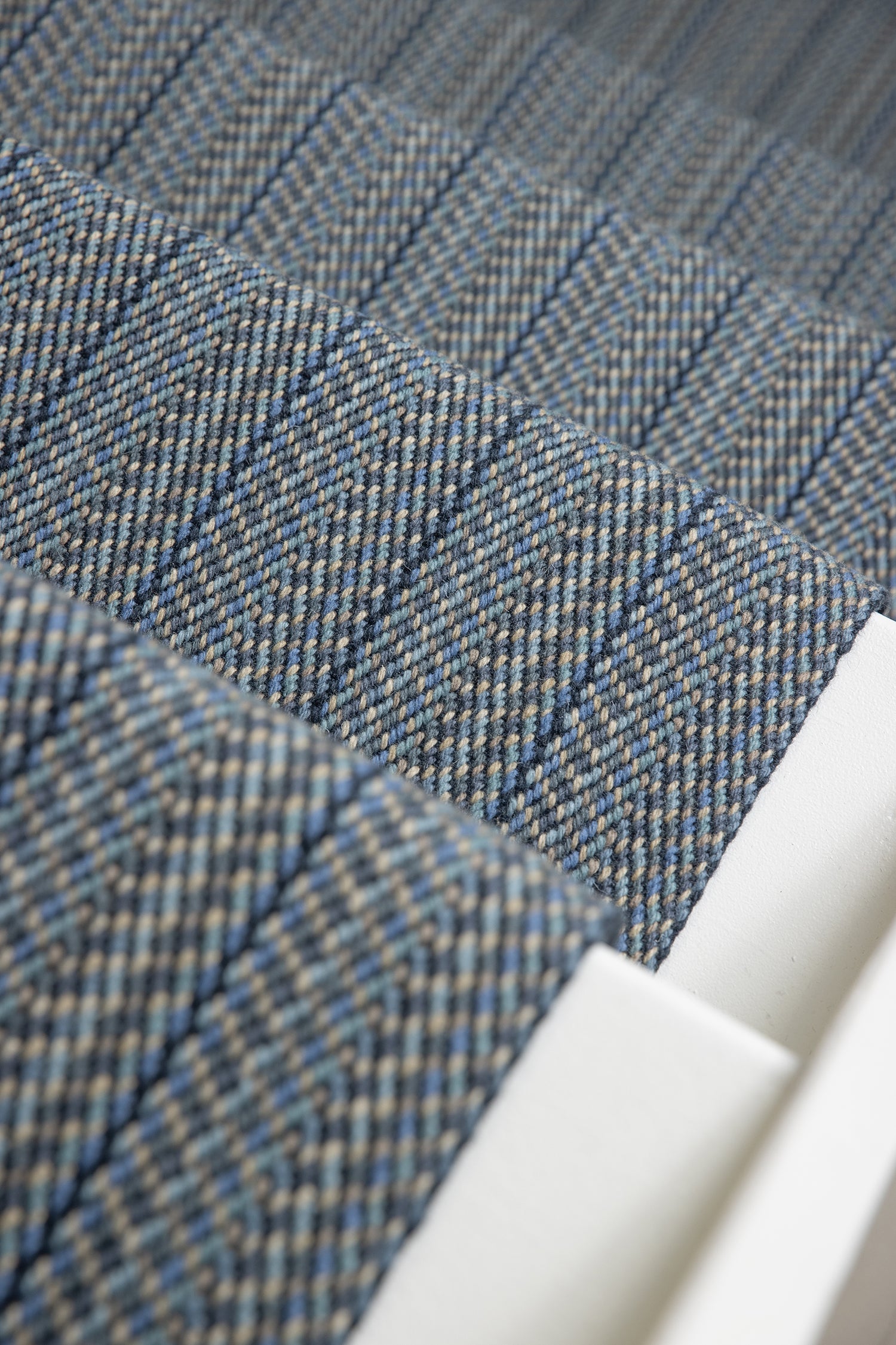 Close-up of a stair runner in blue-gray herringbone weave.