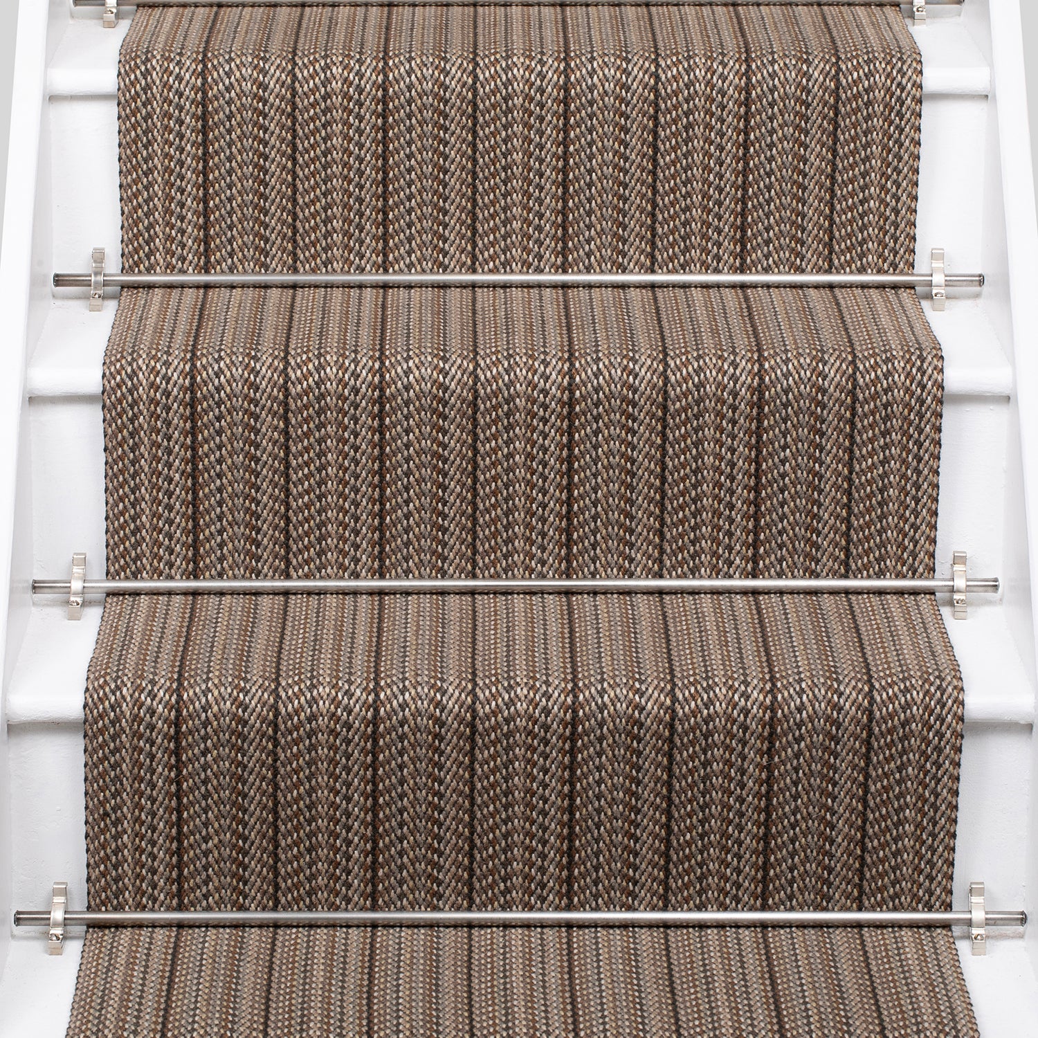 A close-up view of a staircase with carpeted steps in a taupe-brown stripe pattern, bordered by white risers