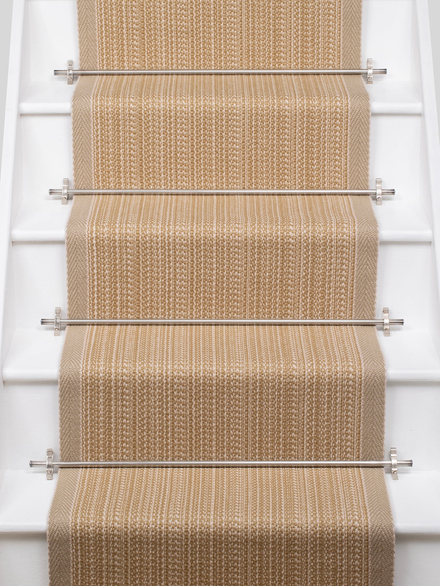 White stairs with textural striped runner in warm tan with metal stair rails. 