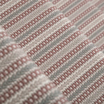 Detail of a stair runner in a complex woven stripe design of wool in shades of pink and grey.