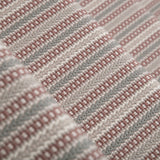 Detail of a stair runner in a complex woven stripe design of wool in shades of pink and grey.