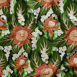 Close up of tropical floral gently draped printed linen featuring orange and red blossoms with creamcenters, dark green leaves on a navy blue background.
