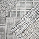 Broadloom carpet samples in a plaid pattern in a range of neutral colors. 