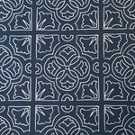 Detail of fabric in a damask lattice print in white on a navy field.