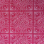Detail of fabric in a damask lattice print in pink on a fuchsia field.