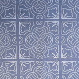 Detail of fabric in a damask lattice print in white on a blue field.