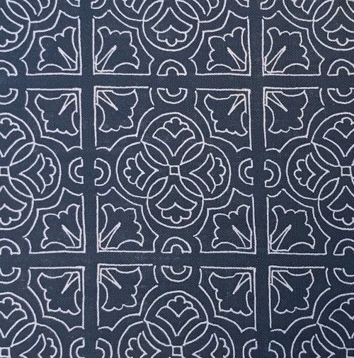 Detail of fabric in a damask lattice print in white on a navy field.