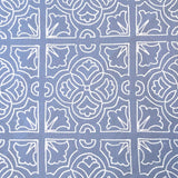Detail of fabric in a damask lattice print in white on a blue field.