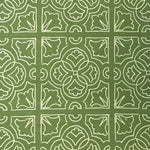 Detail of fabric in a damask lattice print in white on a green field.