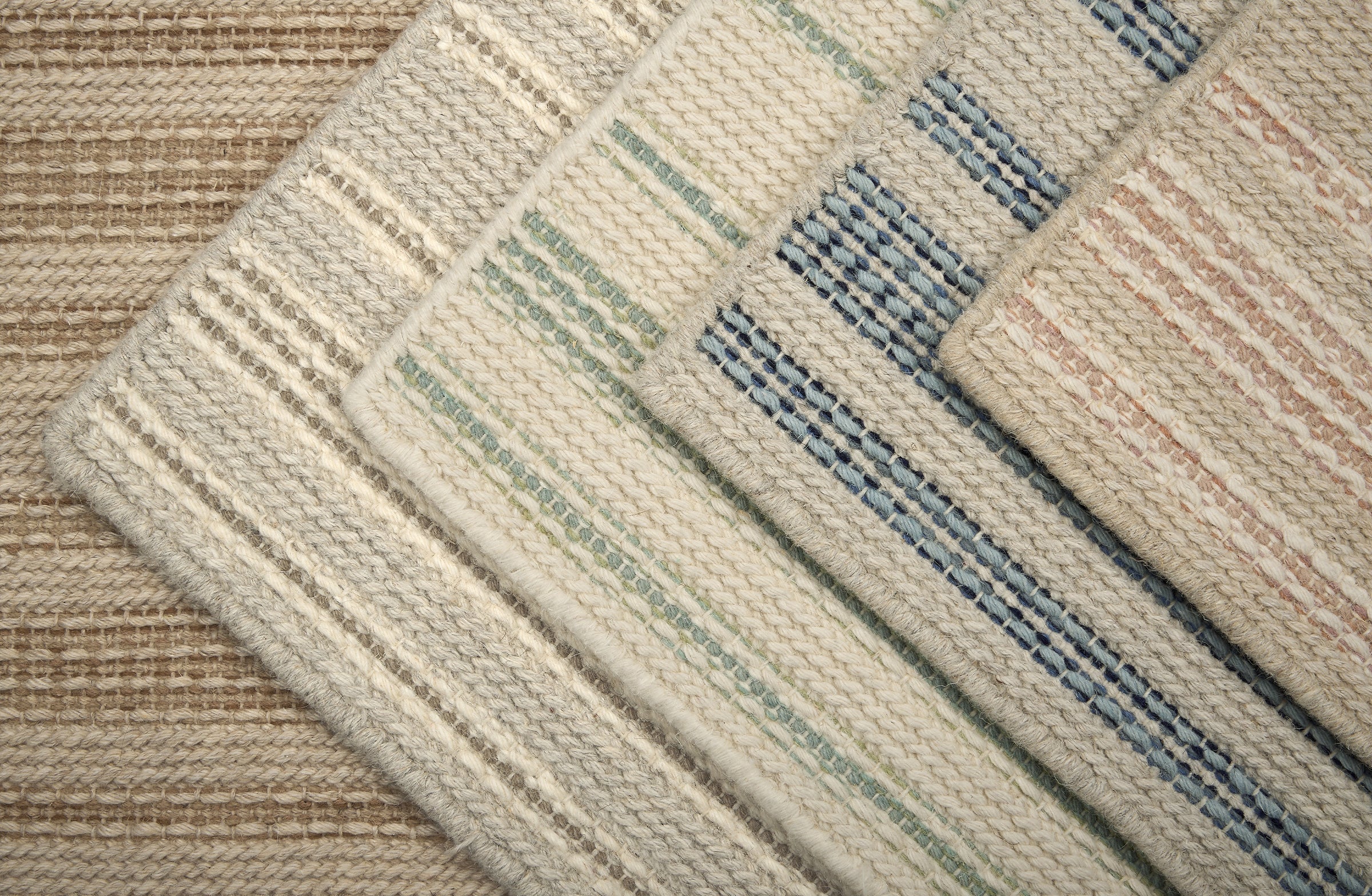Stack of striped broadloom carpet samples in an array of colors. 