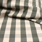 Detail of a draped hand-woven cotton fabric in soft cream in a plaid windowpane patter in cream, brown, teal and taupe.