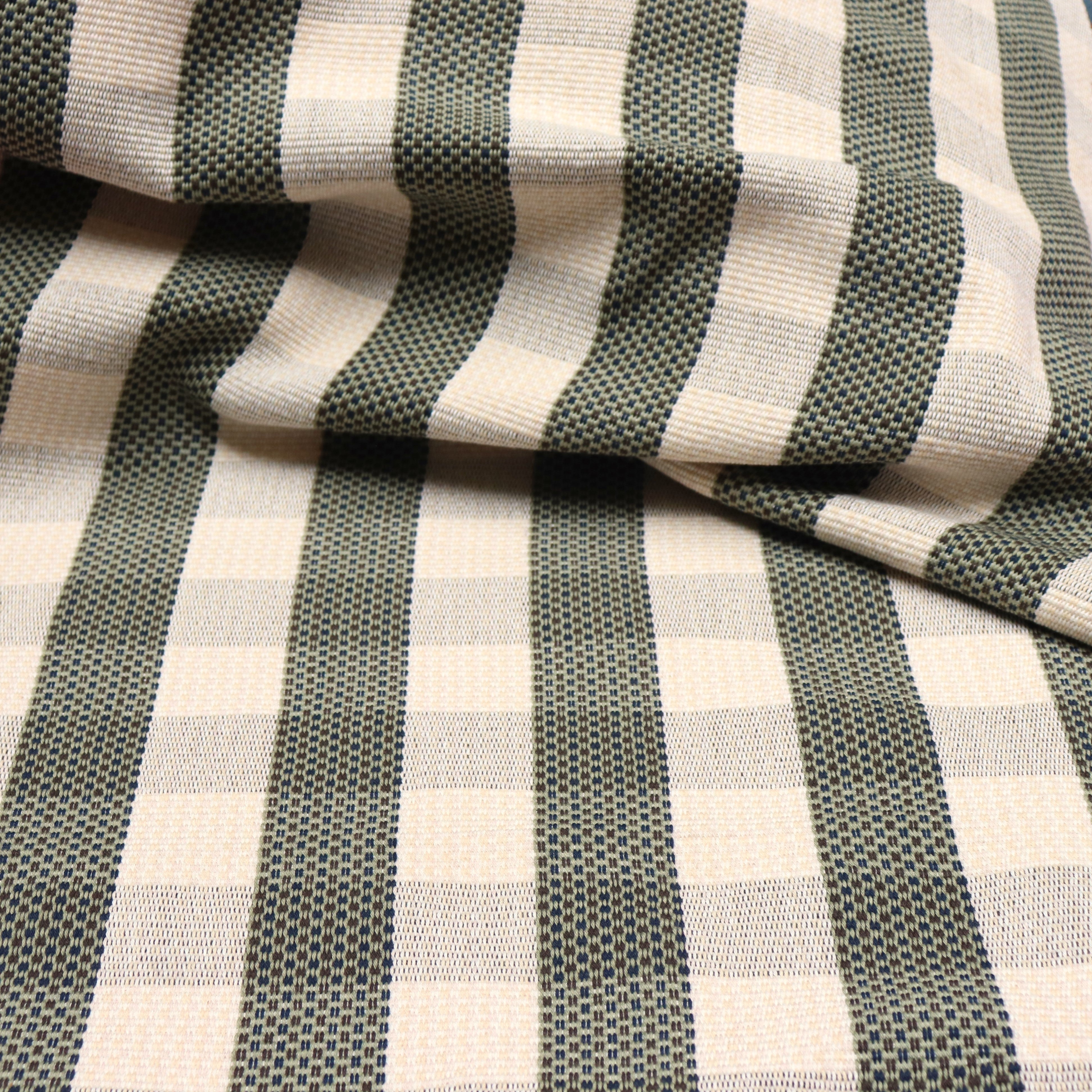 Detail of a draped hand-woven cotton fabric in soft cream in a plaid windowpane patter in cream, brown, teal and taupe.