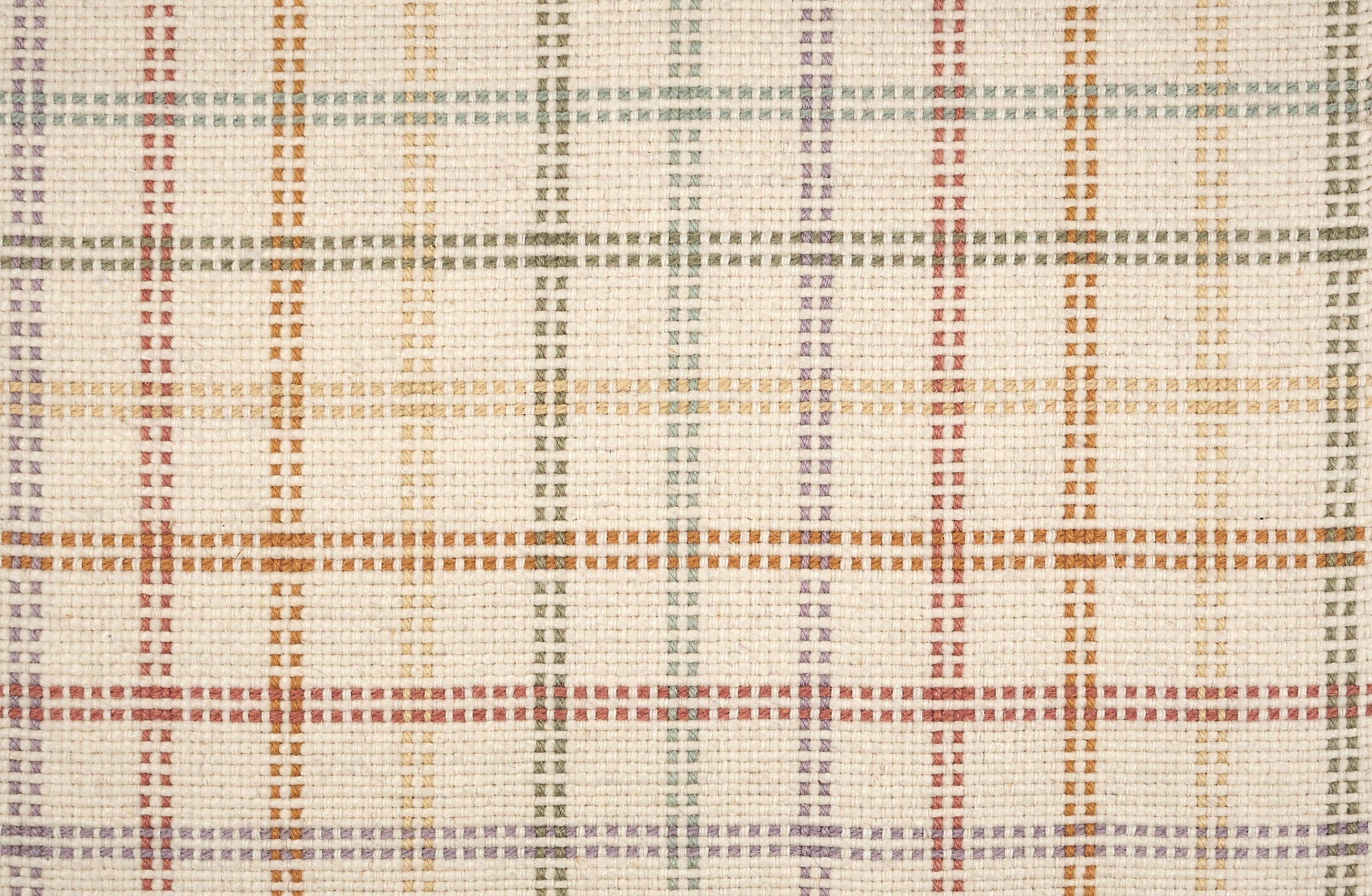 Broadloom carpet in a dashed window pane plaid in green, yellow, purple and orange on a cream field.
