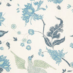 Detail of fabric in a bird and botanical print in shades of blue and green on a cream field.