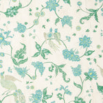 Detail of fabric in a bird and botanical print in shades of green, turquoise and yellow on a cream field.