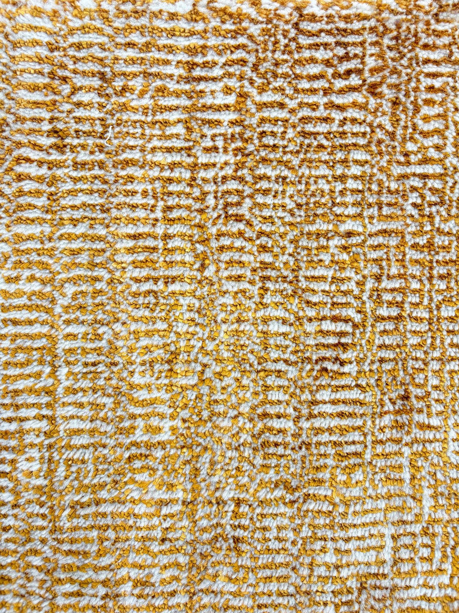 Handknotted rug sample in a textural blend of amber and ivory. 