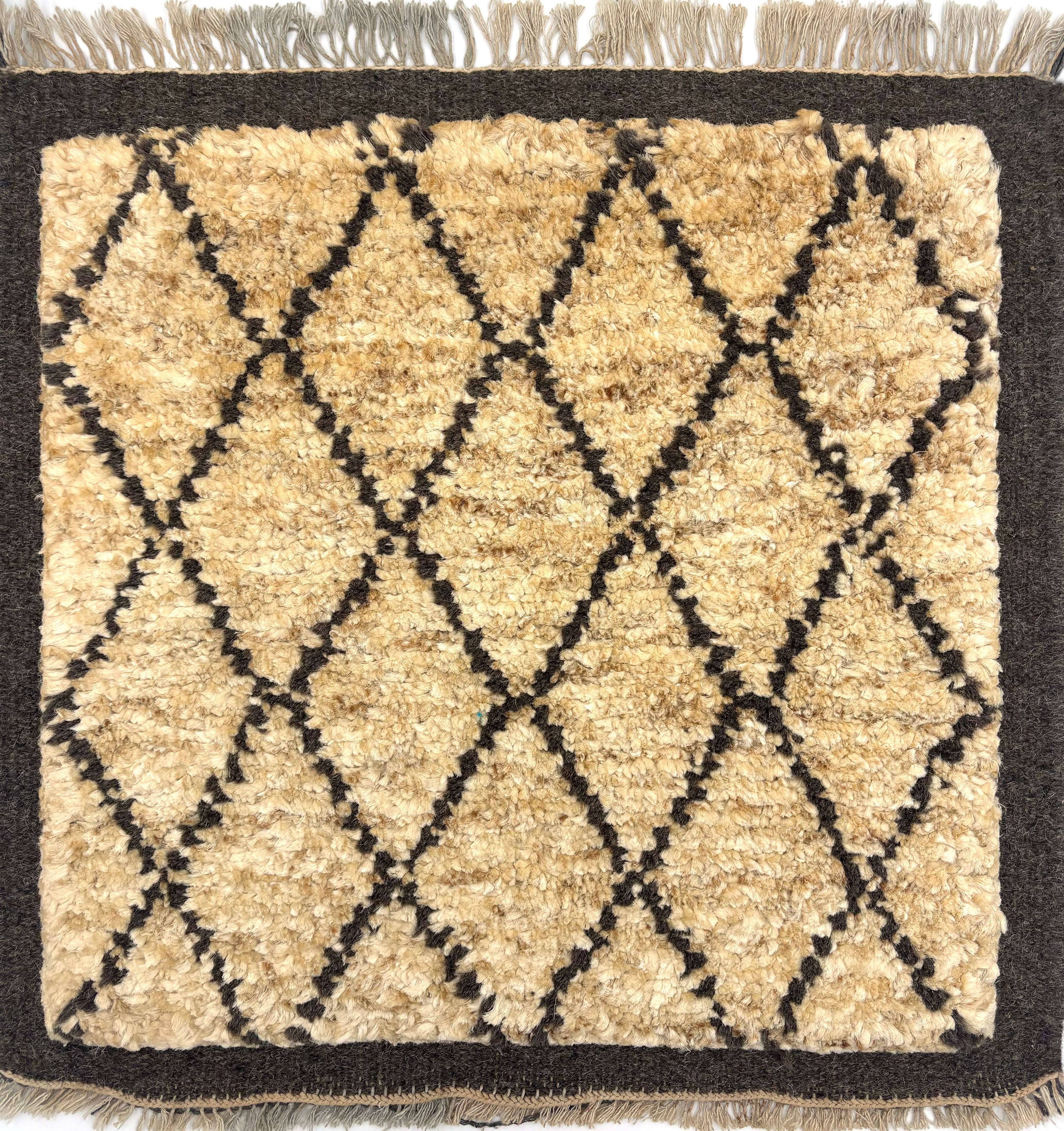 Handknotted Rug in the Moroccan style in a charcoal grey lattice motif and border against a tan wool field. 