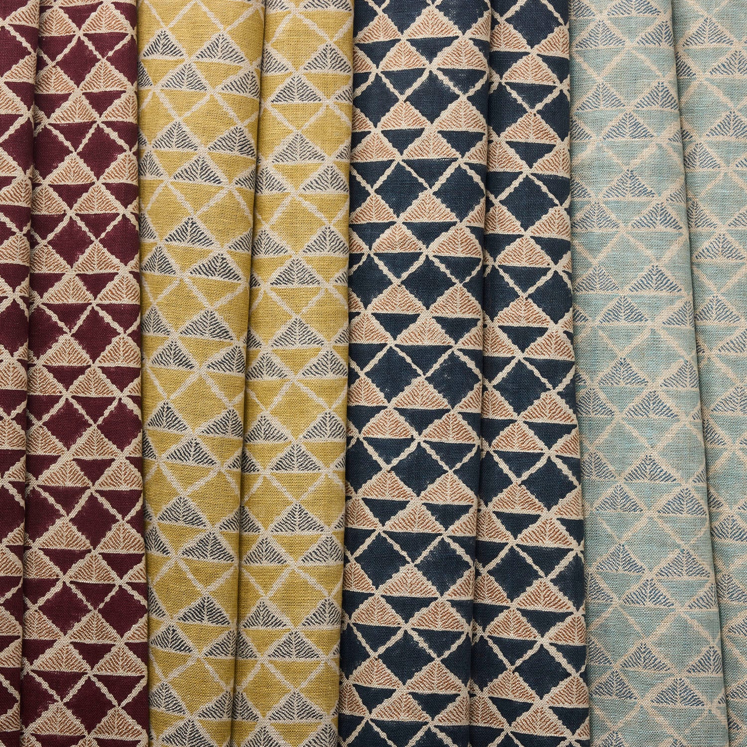 Collection of fabric swatches with geometric triangle patterns in various colors.