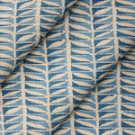 Draped close-up of fabric with a geometric leaf pattern in blue.