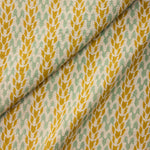 Draped fabric with a pattern of yellow and green leaves on a neutral background