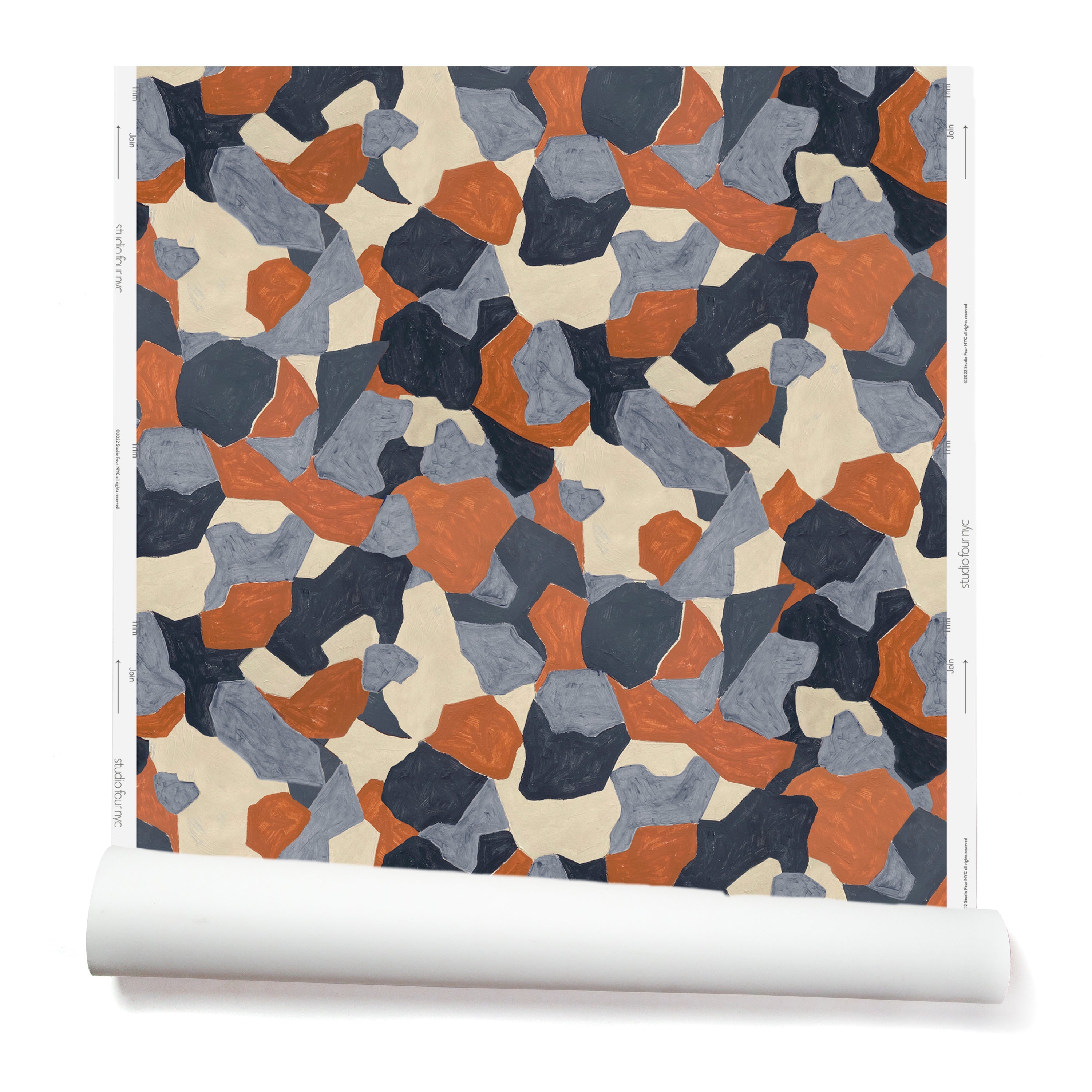 Partially unrolled wallpaper in a painterly geometric pattern in shades of blue, cream and rust.