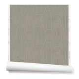 Partially unrolled wallpaper in a repeating curvolinear print in white on a painted gray field.