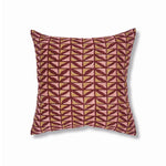 Block printed lumbar pillow with gridded leaf design in wine red with tan and pink accents. 