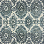 Detail of a handknotted rug with a floral medallion pattern in shades of acqua and grey. 