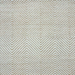 Detail of a handwoven rug in a chevron pattern in natural raffia and ivory yarn