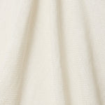 A draped swatch of open-weave sheer interior fabric in a cream color.