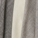A row of three draped sheer interior fabric swatches in mottled gray and cream.