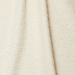 Draped piece of high-pile bouclé fabric in cream.