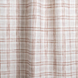 Draped fabric with watercolor plaid pattern in shades of brick red. 