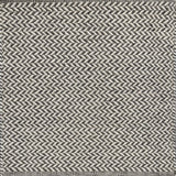 Textured rug with a herringbone pattern in white and dark grey.