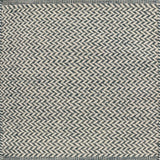Textured rug with a herringbone pattern in white and teal.