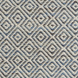 Detail of handwoven rug with diamond pattern in cream and shades of blue and brown.
